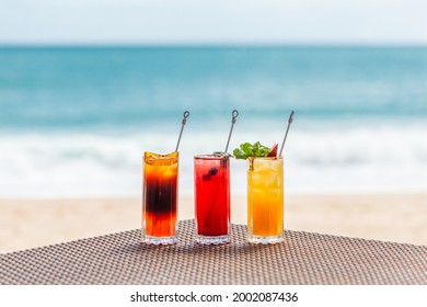 Bright Healthy Berries Cocktails on Table on Beach with Blue Sea on Background. Concept of Summer Vacations at Maldives or Caribbean Resorts. Fresh Fruit Ice Cold Drinks for Hot Weather Refreshment. - Shutterstock ID 2002087436