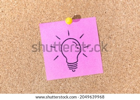 Bright Idea or Creative process concept. Light bulb drawing on sticky note on cork board