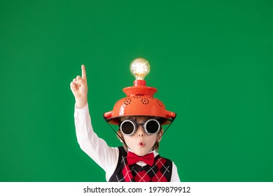 Bright idea! Funny child student in class. Happy kid against green chalkboard. Online education and e-learning concept. Back to school. Education, start up and business idea concept