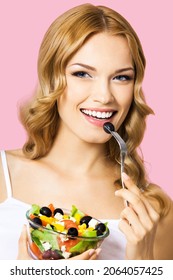 Bright Image Of Smiling Woman Holding Salad With Cheese And Fresh Vegetables, Black Olives, Rose Pink Background. Blond Girl At Studio. Keto Ketogenic Diet, Healthy Eating Concept. Greek Salad.