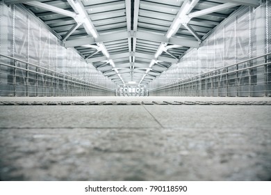 Bright industrial interior tunnel with concrete floor and metal roof