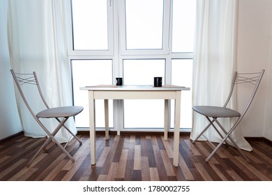 bright interior with empty windows, table and two chairs