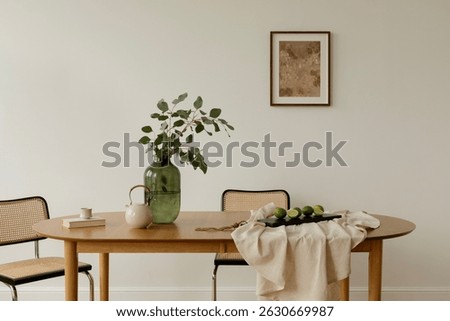 Bright interior with minimalist setup, a dining table styled with greenery, teapot, and limes on neutral linen. Scandinavian and Japanese design influences.