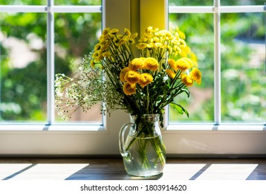 Bright Interior Of The Room With Window On The Blurred Autumn Courtyard Background. Golden Autumn Landscape In White Window With Autumn Flowers. Home And Garden, Fall Concept.