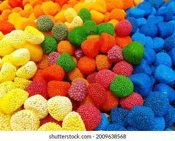 Bright and juicy gummy candies.  The chocolates are poured in a large pile of different colors and sizes.
