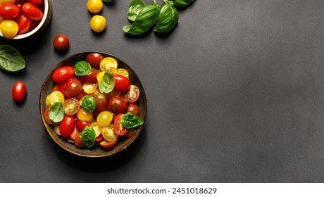 Bright juicy salad with colorful cherry tomatoes and aromatic basil leaves on black stone table close up. Healthy vegan food concept. Copy space for your text.
 - Powered by Shutterstock