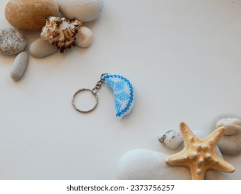 Bright key chain on a white. Bead colorful key chain and stones