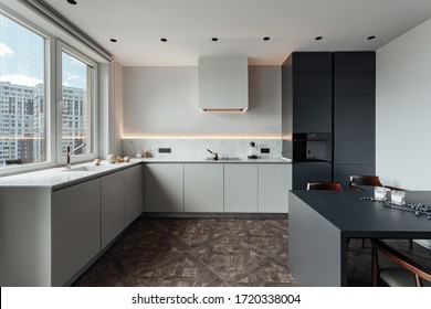 Bright Kitchen With Dark Table, Convenient Location Of Kitchen Accessories And Equipment, Modern Style, White Walls, Marble Working Surface And Parquet Floor. There S A Glass Of Milk On The Table And