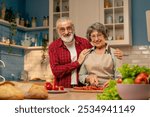 in a bright kitchen an elderly woman in a light green shirt with her husband are preparing healthy dinner cutting vegetables looking at the camera