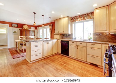 Bright Kitchen Room With Enclosed Dining Area. Light Tones Furniture And Contrast Red Color Walls