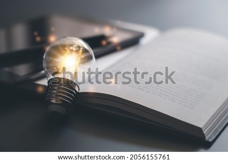 Bright lamp or glowing light bulb with book or textbook. Business success idea or solution concept. Thinking power of business person or professional. Working, studying or learning inspiration