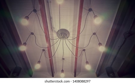
A bright lamp mounted on a white wooden ceiling inside the house. - Powered by Shutterstock