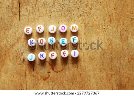 Bright letters beads on a wooden rough surface