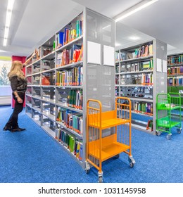 Bright Library Interior With Modern Shelves And Colorful Trolley