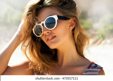 Bright lifestyle fashion portrait of sensual beautiful young woman having fun smiling pretty , natural beauty face,skin care, bright casual trendy sunglasses,bright sexy make up, traveling mood,date
