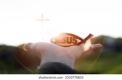 Bright light new year sunrise and christian symbol fish shape ichthys and jesus and church cross
 - Shutterstock ID 2310770833