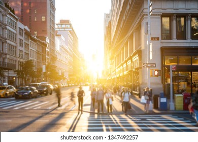 Bright Light Of Sunset Shines On Crowds Of People Crossing The Busy Intersection On 5th Avenue In Manhattan, New York City