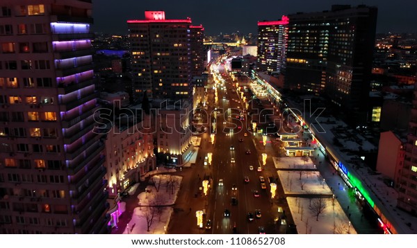 Bright lights of night Moscow from bird's eye
view. Intensive traffic at New Arbat street in the heart of the
city. Multistory houses illuminated with neon lights on the sides
of the wide avenue.