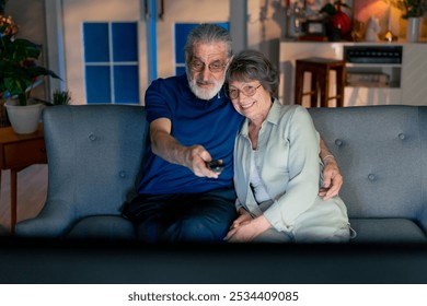 a bright living room with sofa grandma and grandpa watching tv switching channels leisure of elderly people happy couple - Powered by Shutterstock