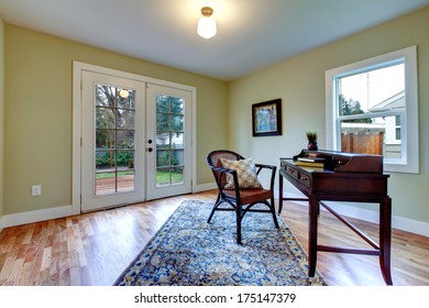 Bright Living Room With Walkout Deck Furnished With Antique Desk And Rustic Chair.