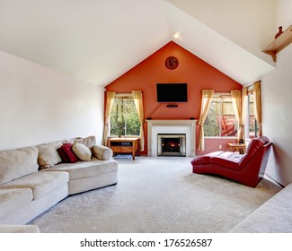 Bright Living Room With White And Orange Wall,  Vaulted Ceiling, Beige Carpet Floor. Fireplace With Red Armless Chair And Beige Couch Make It Cozy And Comfortable