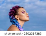 Bright makeup, rose-colored, braids, pigtails hairstyle. Girl colorful kanekalon braided in her hair. Two thick braids of color hair, a youth hairdo, colored hair braids.