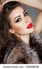 Bright makeup woman with red lips beauty model, Fashion girl brunette smoky eyes makeup, sexy lady vogue style wear fur. Arabian female closeup dark hair long lashes, isolated in studio
