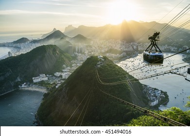 Bright misty view of the city skyline of Rio de Janeiro, Brazil with a Sugarloaf (Pao de Acucar) Mountain cable car passing in the foreground - Powered by Shutterstock