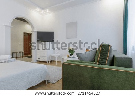 Bright modern studio interior with bed, sofa, soft natural light and cozy decor.