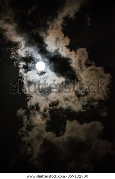 the bright moon behind\
clouds