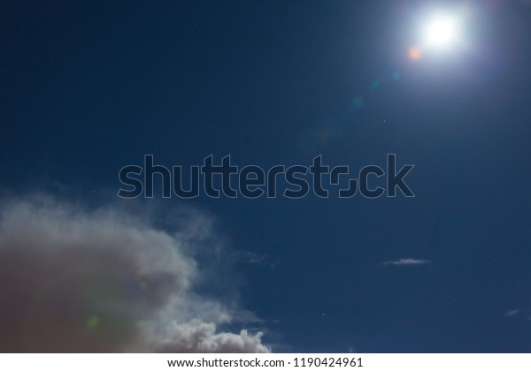 bright moon\
with glare and clouds in the night\
sky