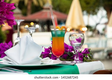 Bright multi-layered cocktail with a straw on a table served for a holiday. Cocktail party at the hotel on the beach. World Cocktail Day - Powered by Shutterstock