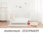 Bright nursery room with a white crib, soft toys, and pastel decor. The nursery room features a white crib, cozy toys, and pastel accents. Peaceful nursery ambiance.