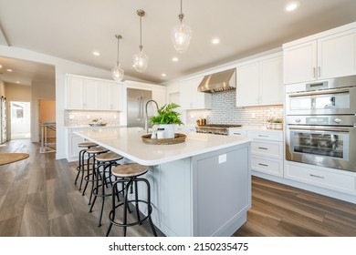 bright open concept kitchen in white with long counter eating space dining room and large windows - Powered by Shutterstock