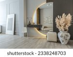 bright open-plan apartment in a modern design, light walls and wooden floor. stylish entrance hall with a beautiful vase and a round mirror and a sofa for guests