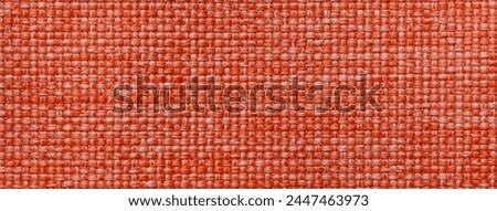 Bright orange background with checkered pattern, closeup. Structure of the fabric macro.