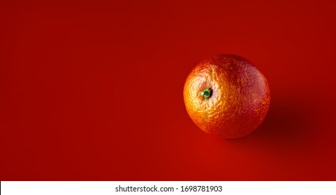 Bright Orange Kara-Kara On A Red Background.. Citrus Sinensis Cara Cara Navel Orange