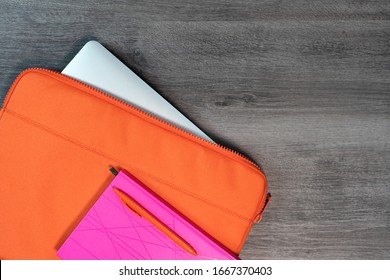 Bright Orange Laptop Case With Pink Note Book And Pen Flatlay