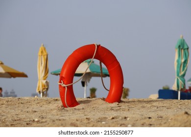 Bright Orange Lifebuoy On A Sandy Beach