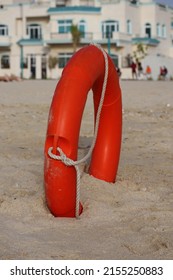 Bright Orange Lifebuoy On A Sandy Beach