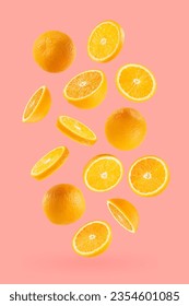 Bright oranges as flow fly or fall as art composition. Whole, half, round slices fruits on pastel pink background with shadow. Tropical fruits for advertising, design, label product, poster, card.