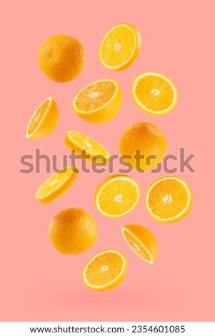 Bright oranges as flow fly or fall as art composition. Whole, half, round slices fruits on pastel pink background with shadow. Tropical fruits for advertising, design, label product, poster, card.