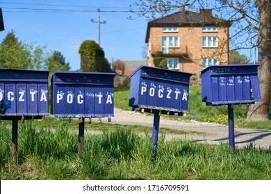 Bright Outdoor Cluster Mail Boxes With Individual Slots In Rural Poland. The Text In Polish On The Mailbox Translates To: 'The Post Office Of Poland'                               