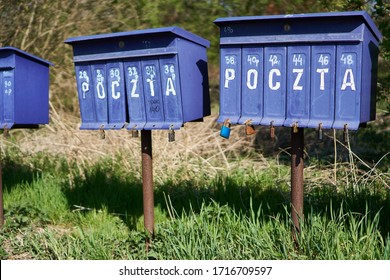 Bright Outdoor Cluster Mail Boxes With Individual Slots In Rural Poland. The Text In Polish On The Mailbox Translates To: 'The Post Office Of Poland'                               