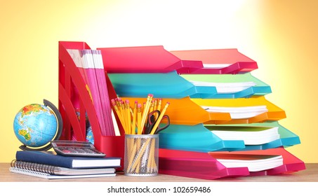 bright paper trays and stationery on wooden table on yellow background - Powered by Shutterstock