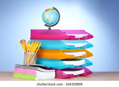 bright paper trays and stationery on wooden table on blue background - Powered by Shutterstock