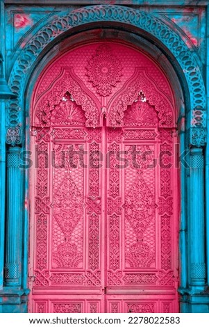 A bright pink door with oriental patterns and a blue frame. Art oriental architecture poster.