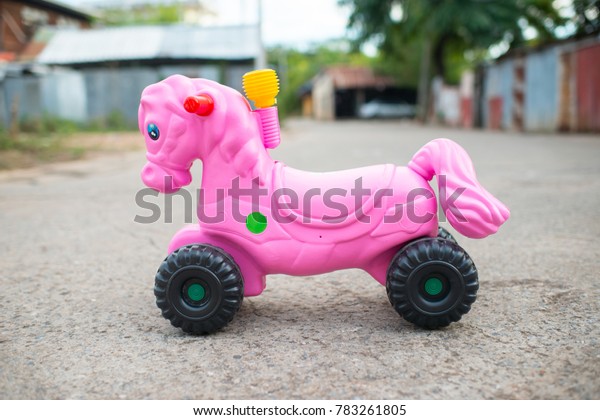 Bright pink\
toy horse with wheels and air\
horns.\
