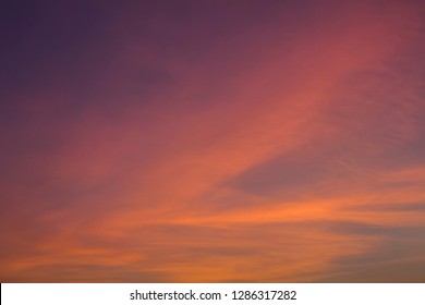 bright pink and yellow clouds in a dark blue purple sunset sky - Shutterstock ID 1286317282