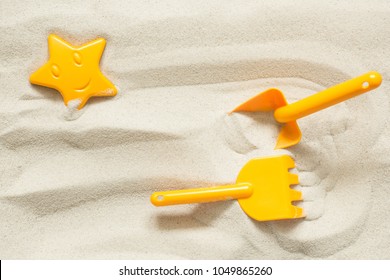 Bright Plastic Children's Toys In The Sand. Concept Of Beach Recreation For Children. Top View. Space For Text.